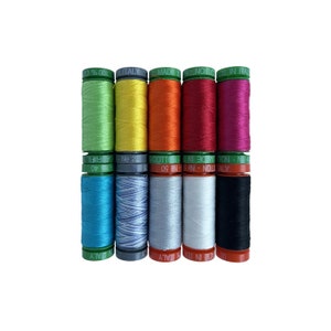 May include: A set of ten spools of thread in various colors, including green, yellow, orange, red, pink, blue, gray, and black. The spools are labeled with the text "Made in Italy" and "100% Cotton".