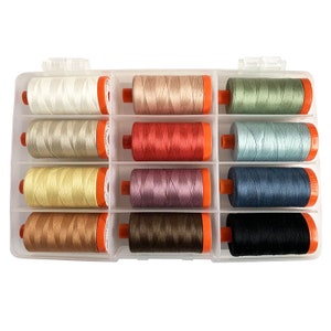 May include: A clear plastic storage box with 12 spools of thread. The spools are arranged in two rows of six. The spools are in various colors, including white, beige, red, pink, blue, green, brown, and black.