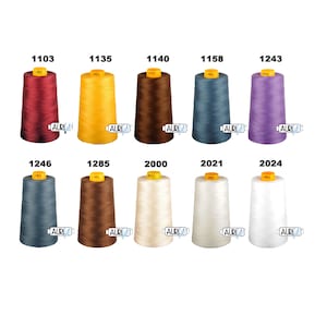 Puede incluir: Una colección de diez carretes de hilo en varios colores, incluyendo rojo, amarillo, marrón, azul, morado, beige y blanco. Cada carrete está etiquetado con un número, como 1103, 1135, 1140, 1158, 1243, 1246, 1285, 2000, 2021 y 2024.