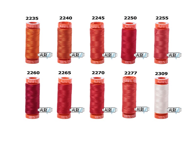 May include: A collection of ten spools of Aurifil thread in various shades of red, orange, and white. The spools are labelled with their corresponding numbers: 2235, 2240, 2245, 2250, 2255, 2260, 2265, 2270, 2277, and 2309.