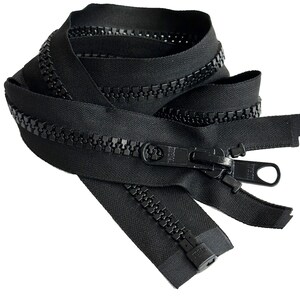 Puede incluir: Cinta de cremallera negra con un tirador de cremallera negro. El tirador de la cremallera tiene la palabra "IDEAL" impresa.