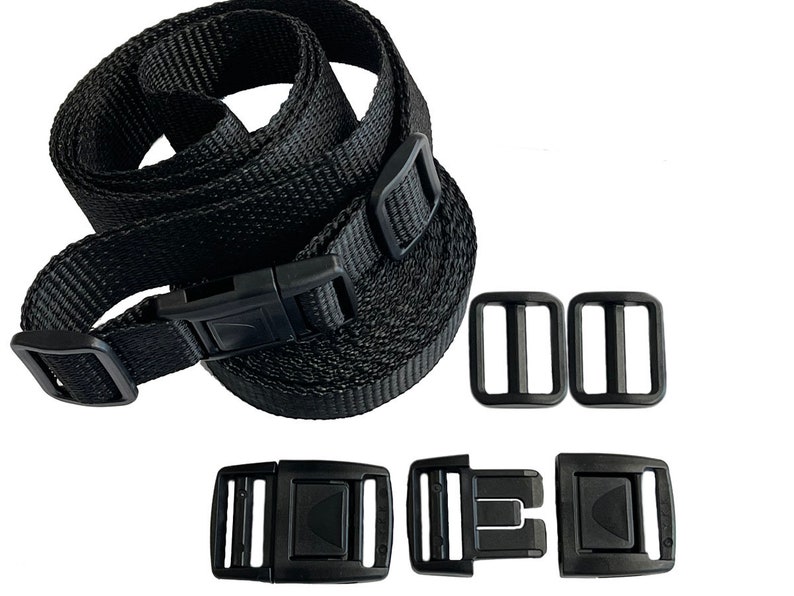 May include: Black nylon straps with black plastic buckles and sliders. The straps are coiled and the buckles are laid out separately.