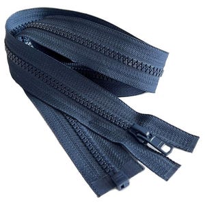 Puede incluir: Primer plano de una cremallera azul oscuro con un deslizador negro. La cremallera está doblada por la mitad y el deslizador está en el medio de la cremallera.