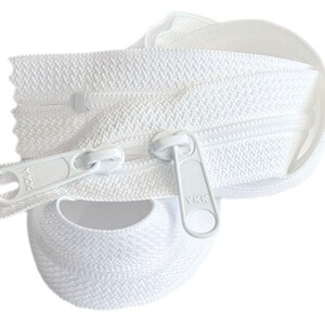 May include: White zipper tape with a white zipper pull. The zipper pull has the text "YKK" on it.
