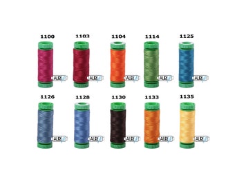 May include: A collection of ten spools of Aurifil 100% cotton thread in various colors. Each spool is cylindrical with a green top and base, and a label with a color number. Colors include shades of pink, red, orange, green, blue, and yellow.