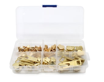 May include: A clear plastic storage box with multiple compartments filled with gold-colored metal zipper pulls and sliders.