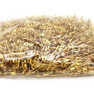 May include: A large plastic bag filled with gold safety pins.