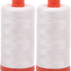 May include: Two spools of white thread with orange plastic tops and bottoms. The spools are labeled "100% POLY"