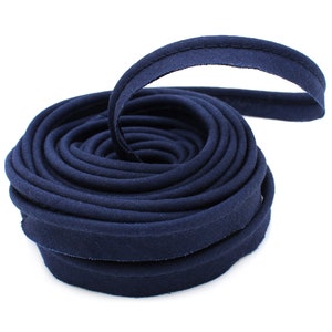 May include: A roll of dark blue fabric trim, coiled and ready for sewing projects.