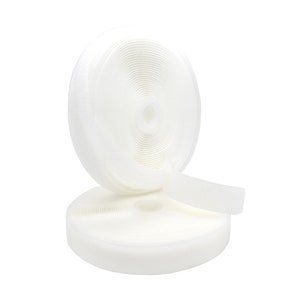 May include: A roll of white hook and loop fastener tape. The tape is rolled up and is ready to be used for a variety of projects.
