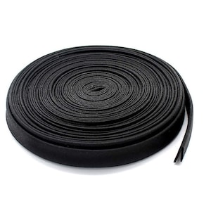 May include: A roll of black bias tape, a type of fabric trim used for finishing edges of garments and home decor projects.
