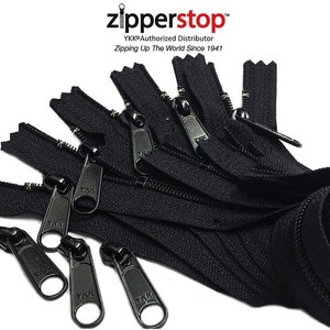May include: A close-up of ten black zipper pulls with gold teeth. The zippers are arranged in a pile and are all the same length. The zipper pulls are made of metal and have a YKK logo on them. The text "zipperstop™" is visible in the top left corner of the image. The text "YKK® Authorized Distributor" is visible below the zipperstop™ logo. The text "Zipping Up The World Since 1941" is visible below the "YKK® Authorized Distributor" text.