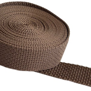 May include: A roll of brown webbing strap, a type of heavy-duty nylon fabric used for various purposes, such as crafting, sewing, and making straps.