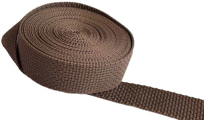 May include: A roll of brown webbing strap, a type of heavy-duty nylon fabric used for various purposes, such as crafting, sewing, and making straps.