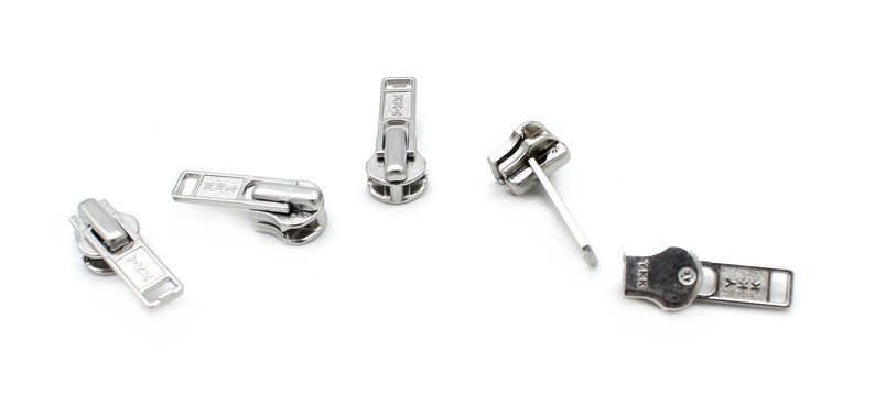 May include: Five silver zipper pulls, some with a slider and some with a pull tab. The zipper pulls are all metal and have a shiny finish.