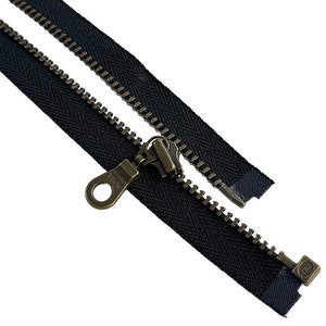 May include: A black zipper with antique brass hardware. The zipper is open and the slider is visible. The zipper is approximately 10 inches long.