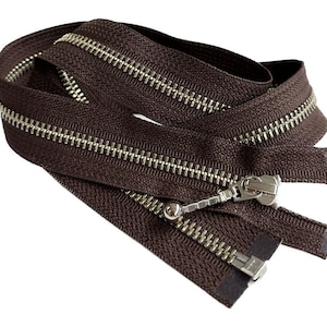 May include: Brown zipper with silver teeth and a silver slider. The zipper is folded in half and the slider is in the middle of the zipper.