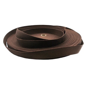May include: A roll of brown webbing, a type of strong, woven fabric often used for straps and belts.