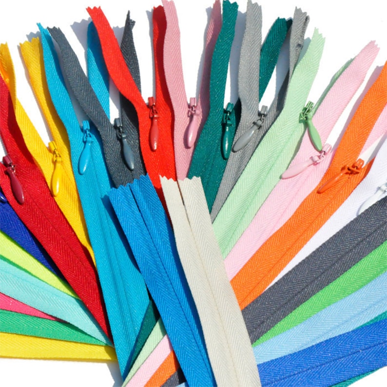 May include: Assortment of colorful zipper tapes in various colors, including red, blue, green, yellow, orange, pink, and white. The zippers are laid out in a fan shape, showcasing the different colors and styles.