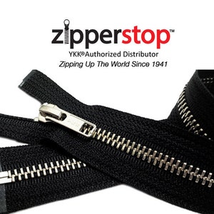 May include: Black zipper with silver teeth and a silver slider. The zipper is folded in half and the slider is in the middle of the zipper. The zipper is labeled "zipperstop" and "YKK® Authorized Distributor Zipping Up The World Since 1941".