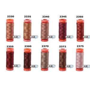 May include: Ten spools of Aurifil thread in various shades of brown, red, and beige. Each spool is labeled with the Aurifil logo and the thread number.