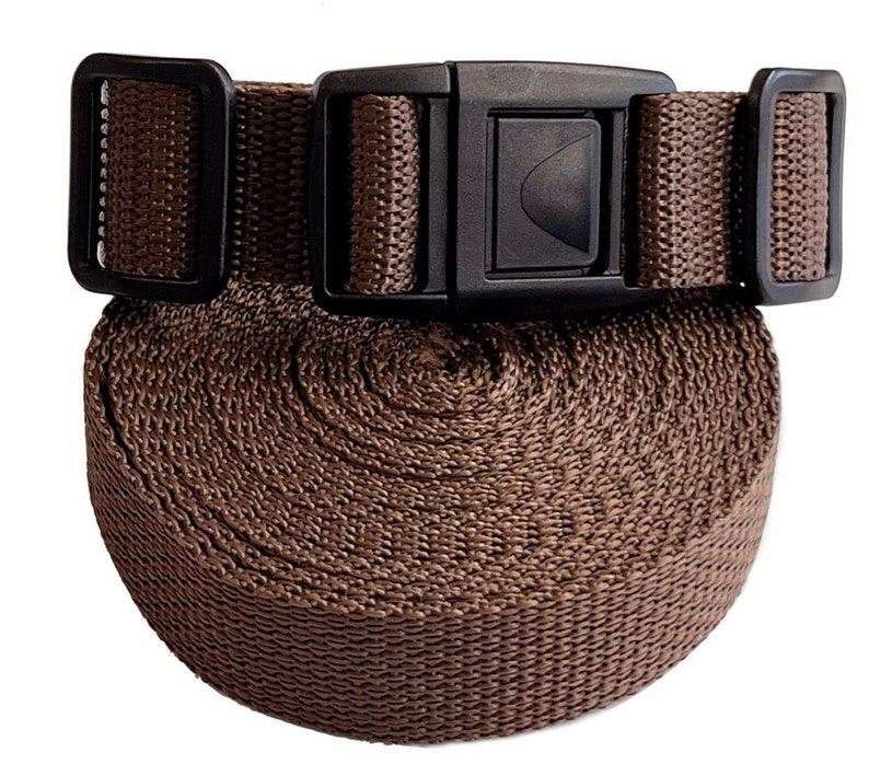 May include: A brown nylon strap with a black plastic buckle. The strap is rolled up and the buckle is visible.