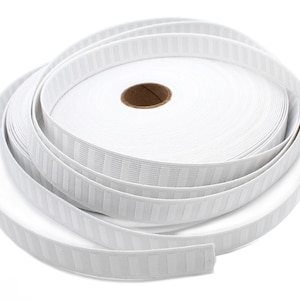 May include: A roll of white curtain heading tape, unrolled to show the textured vertical stripes. The tape is made of a woven material and is used for creating pleats in curtains or other fabric projects.