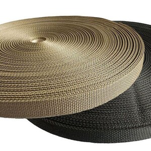 May include: Two spools of webbing, one in black and one in tan. The spools are wound tightly and are ready to be used for crafting or other projects.