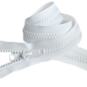 Puede incluir: Cremallera blanca con un deslizador de plástico. La cremallera está enrollada y lista para ser cosida en una prenda.