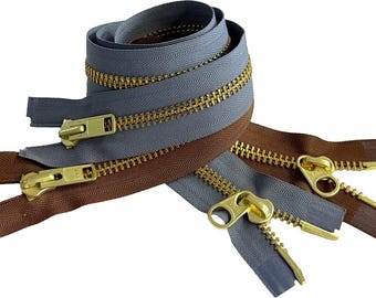 May include: Three zipper tapes in brown and blue with gold metal teeth and pulls. The zipper tapes are layered on top of each other.