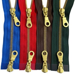 May include: Five different coloured zipper tapes with gold metal zipper pulls. The zipper pulls have a YKK logo.