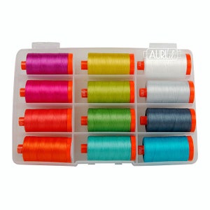 May include: A clear plastic storage case with 12 spools of thread. The spools are in various colors, including pink, yellow, green, orange, blue, and gray. The case has a label that says "Aurifil".