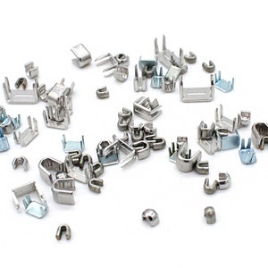 May include: A collection of silver metal zipper pulls, some with a U-shape and others with a rectangular shape.
