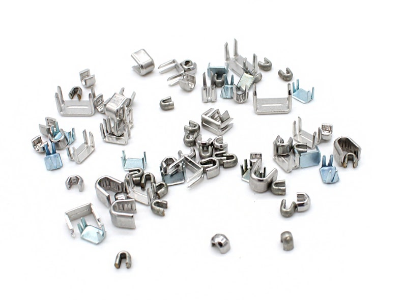 May include: A collection of silver metal zipper pulls, some with a U-shape and others with a rectangular shape.