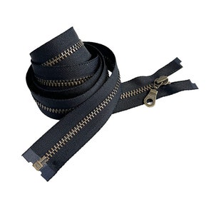 May include: A black zipper with a brass slider and pull. The zipper is coiled up and ready to be used for sewing projects.
