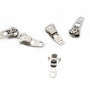 May include: Five silver zipper pulls with the brand name "YKK" printed on them.