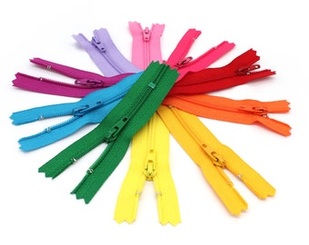 May include: A set of ten colorful zippers arranged in a circle. The zippers are in the colors of the rainbow, starting with purple and ending with yellow.