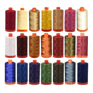 May include: A collection of 20 spools of thread in various colors, including burgundy, butter, cachemire, canary, caramel, carmine red, chalk, chocolate, cinnamon, copper, dark antique gold, dark carmine red, dark cobalt, dark delft blue, dark dusty grape, dark grass green, dark green, dark gray, dark navy, and dark gray. Each spool has a label with the color name and number.