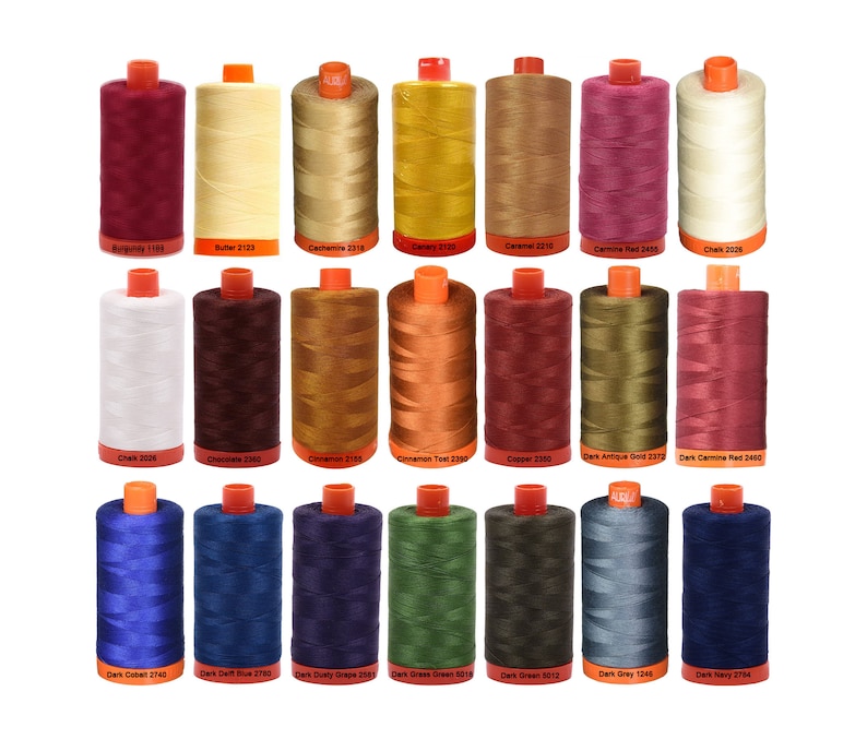 May include: A collection of 20 spools of thread in various colors, including burgundy, butter, cachemire, canary, caramel, carmine red, chalk, chocolate, cinnamon, copper, dark antique gold, dark carmine red, dark cobalt, dark delft blue, dark dusty grape, dark grass green, dark green, dark gray, dark navy, and dark gray. Each spool has a label with the color name and number.