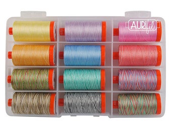 May include: A clear plastic storage box filled with 12 spools of colorful thread. The spools are arranged in rows of four. The thread is a variety of colors, including pink, blue, green, and brown. The box has a label that says "Aurifil" on it.