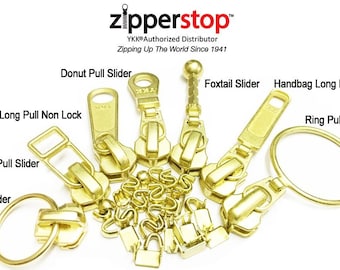 May include: Assortment of gold-colored zipper pulls, including a donut pull slider, a foxtail slider, a handbag long pull slider, a long pull non-lock slider, a bell pull slider, a notch slider, and a ring pull slider.  YKK® Authorized Distributor. Zipping Up The World Since 1941.