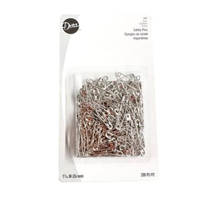 May include: A package of 200 silver safety pins, 1 1/16 inches in size. The package is labeled "Safety Pins" and "Épingles de sûreté Imperdibles".