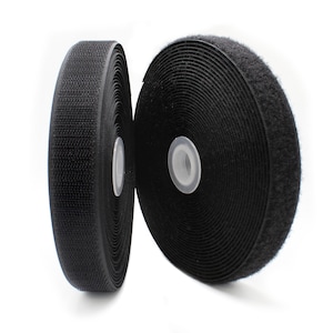 May include: Two rolls of black hook and loop fastener tape. The tape is rolled up and the ends are visible.