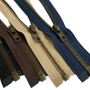 May include: Four zipper closures with antique brass sliders and teeth. The zippers are in different colors: black, brown, beige, and navy blue.