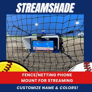 May include: A blue phone mount with a white sunshade is attached to a black net. The phone displays a game, and the text "Diamond Dogs" is visible. The text "STREAMSHADE" and "FENCE/NETTING PHONE MOUNT FOR STREAMING" are also displayed.