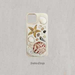 Coque de portable personnalisable inspirée des coquillages côtiers. Chaque article est méticuleusement fabriqué à la main avec des breloques, des coquillages et des perles de haute qualité.