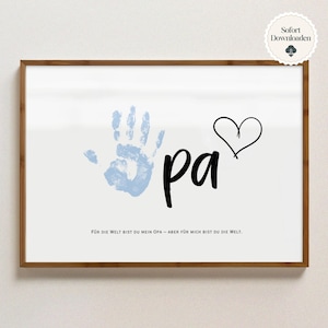 May include: A framed print featuring a light blue handprint, the word "pa" in black script, and a black heart outline. The text "FÜR DIE WELT BIST DU MEIN OPA - ABER FÜR MICH BIST DU DIE WELT" is at the bottom. A small "Sofort Downloaden" sticker is in the top right corner.
