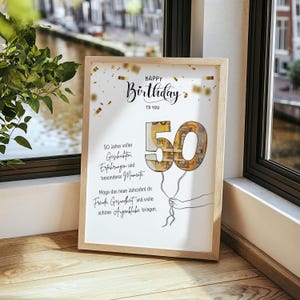 Puede incluir: Un marco de madera clara que contiene una impresi&oacute;n de cumplea&ntilde;os. La impresi&oacute;n dice "Happy Birthday to You" y presenta un "50" hecho de dinero, sostenido por una mano. Confeti dorado decora la parte superior.