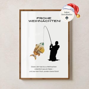以下が含まれることがあります： クリスマスのテーマの額入りプリント。ユーロ紙幣で作られた魚を釣る、釣り竿を持った人のシルエットが描かれています。「FROHE WEIHNACHTEN！」の文字が上部にあります。