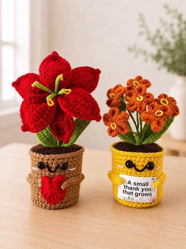 May include: Two crocheted potted plants with smiling faces. The left plant has a large red flower and a brown pot holding a red heart. The right plant has orange flowers in a yellow pot holding a sign that reads A small thank you that grows.